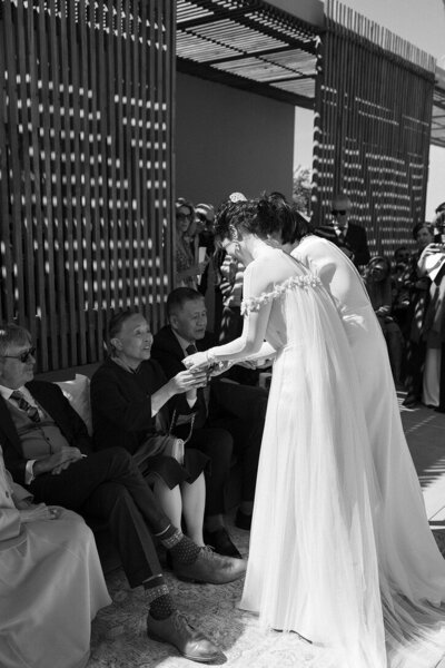 Brides performing tea ceremony during cocktail hour at their luxury wedding in La Jolla. 