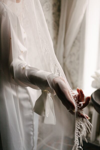 bride holding edge of veil in hand