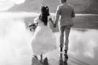 Wedding couple running on the beach taken by Idaho photographer.