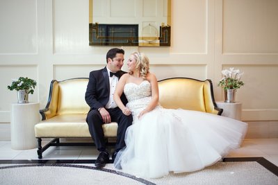 Couple Sitting on couch at London Hotel on their wedding day