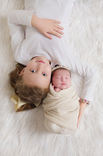 siblings on a white carpet in the studio