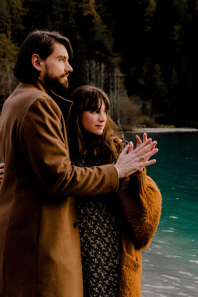 Verliebtes Paar in abendlicher Stimmung vor einem dunkelblauen Bergsee.