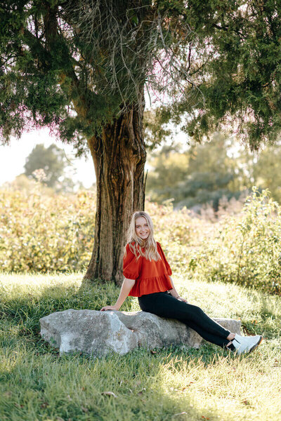 nashville photographers senior pictures in a grass field on rock