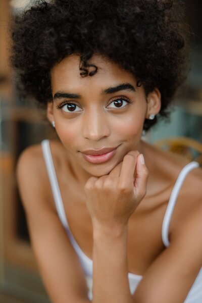 beautiful black girl in white dress looking at camera with big eyes