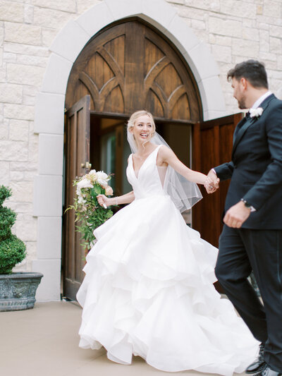 The glowing bride leads her husband of the chapel where their wedding ceremony took place