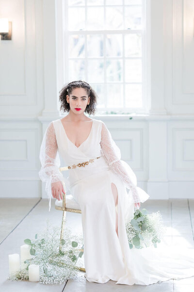 Bride sitting in classic custom wedding dress with lace sleeves