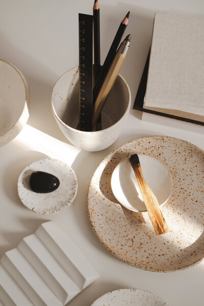 palo santo stick sits next to black onyx crystal on brandy boyett's holistic design workspace.