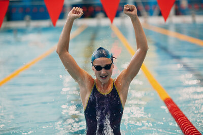 Athlete celebrating victory with hands raised after competition, symbolizing strength, motivation, and peak performance.