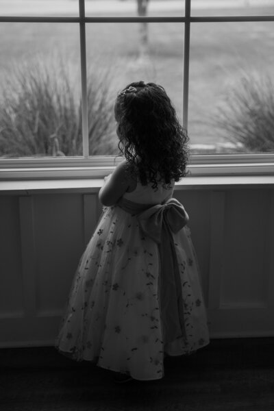 flower girl looking out window dallas texas wedding