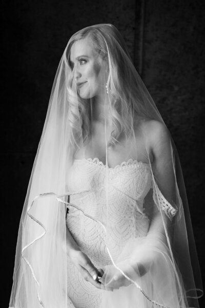 black and white photo of a bride with her veil over her face