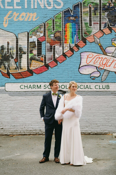 downtown richmond wedding with bride and groom posing in front of a mural on a city building brick wall with bright colors