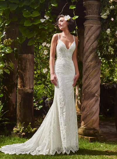 Ivory stretch lace in a sheath silhouette. Long sleeves iwth a scalloped back and cascading train.