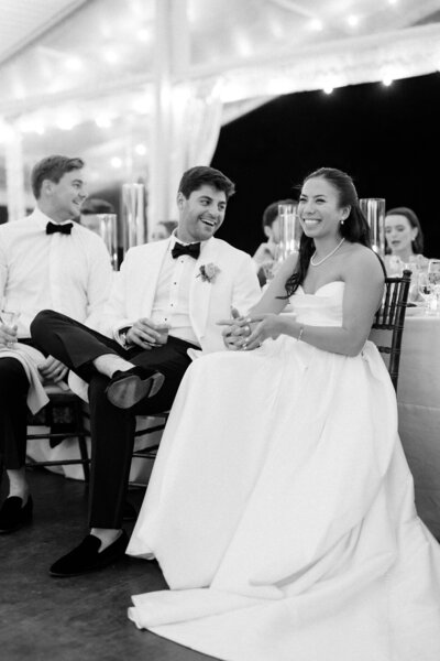 Groom laughs with bride during toasts at Glen Foerd Estate in Philadelphia, PA