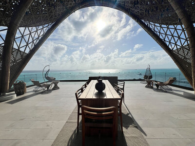 Elegant patio furniture with a table and chairs, overlooking the ocean, ideal for a romantic destination wedding setting.