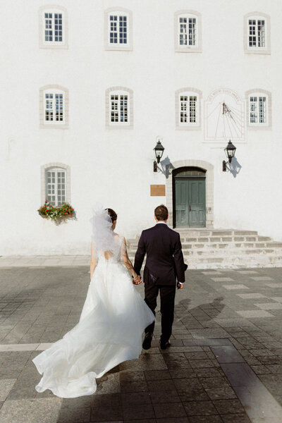 newlyweds-walking-in-the-windy-seminary-courtyard-in-quebec-city
