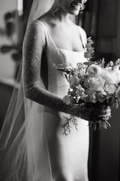 Black and white bridal portrait of bride holding flowers at fairlane station wedding venue in springdale, Arkansas.
