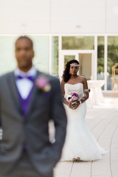 groom has his back to bride in wedding dress