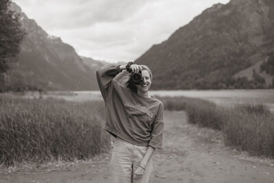 Suli von Suli Photography sitzt auf einem Stuhl und lacht. Sie ist Fotografin in der Schweiz.