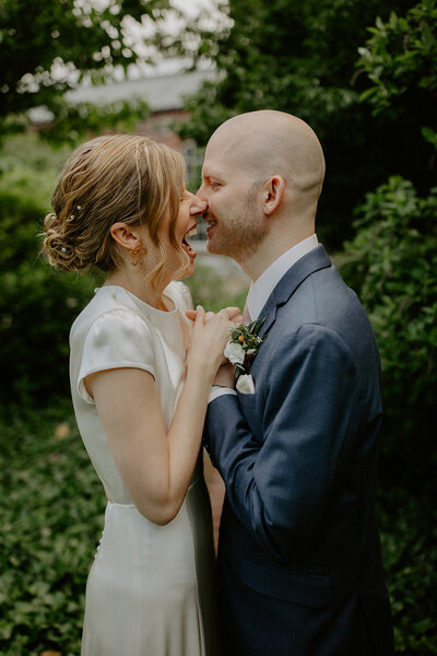 Bride and groom closely embracing while laughing