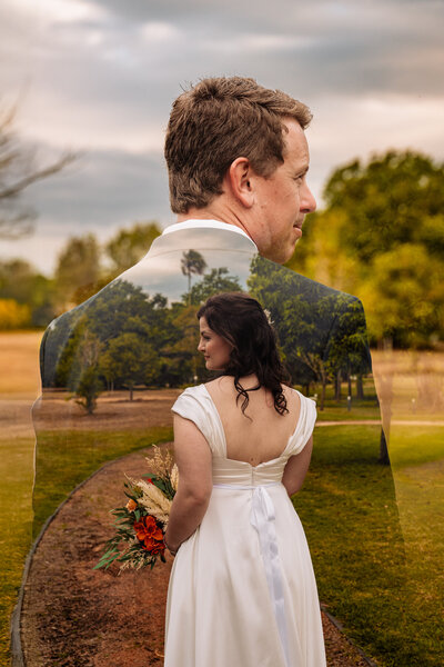 A bride and groom stand together on train tracks surrounded by lush woods, symbolizing love and adventure. - photo by Jamie Simmons