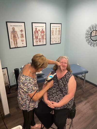 A woman receiving a cryotherapy treatment on her face from a professional at 212 Salon, Spa, & Barbershop, showcasing the spa's therapeutic services.