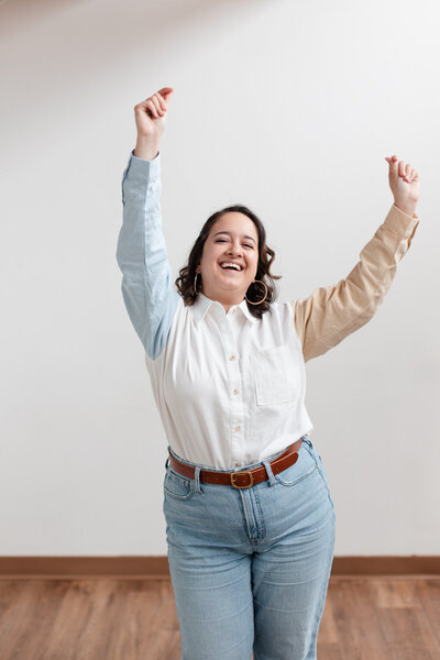woman smiling and dancing with her arms over her head