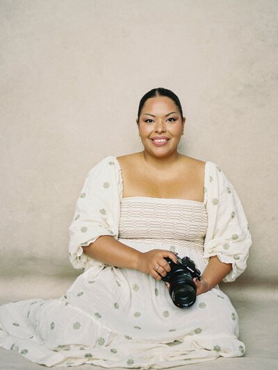 Photo of Jennifer Nolan wearing an Anthropologie dress while she holds her camera.
