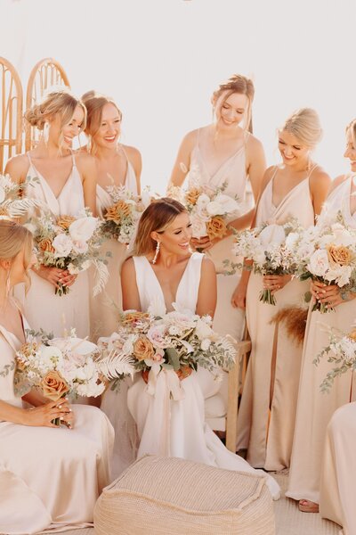 Bride Sitting with Bridal Party Holding Bouquets - Bre & Chris | Converted Basketball Court Wedding – Featured in Brides Magazine