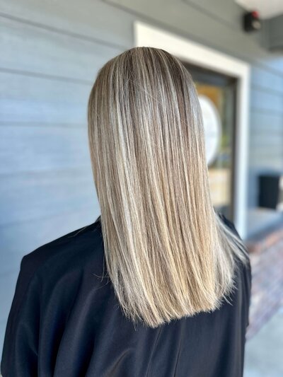 Blunt-cut, shoulder-length blonde hair—example of precision haircut services.