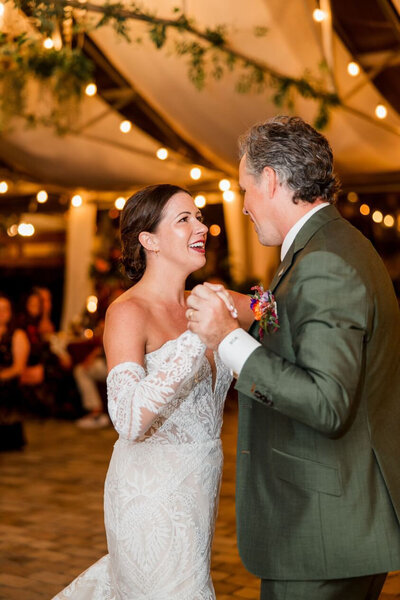 Father and daughter dance in an indoor wedding setup