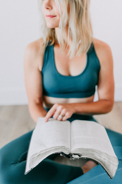 Kelsey Wickenhauser deeply engrossed in her Bible, exploring faith-driven principles of a weight loss Bible study.