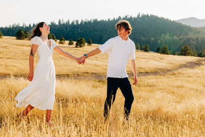 Engagement photo of Missoula couple holding hands and walking at Blue Mountain Trailhead
