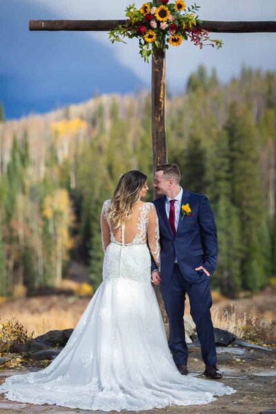 a bride and groom in from of a cross