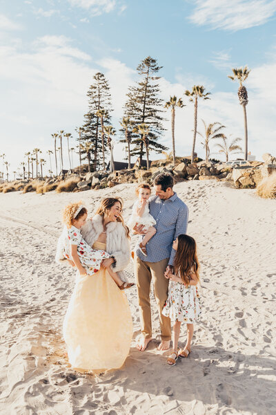 a family walks on the beach together in San Diego near hotel del coronado