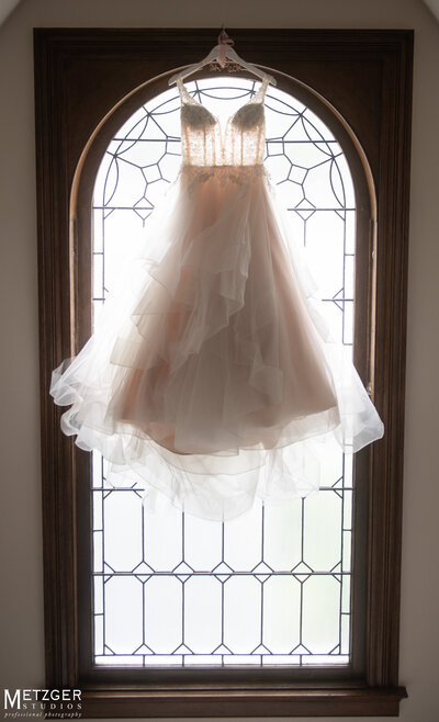 Wedding dress hanging in window