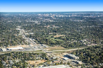 Aerial photograph from an airplane showing a development of buildings in the foreground, and downtown St. Louis in the background.