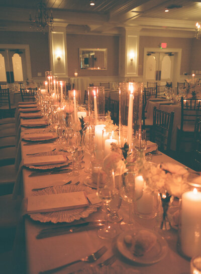 Flatlay arrangement of a white and green bouquet, coupes, wedding stationery, and pearl earings