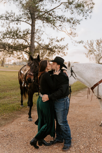 couple embracing by horses