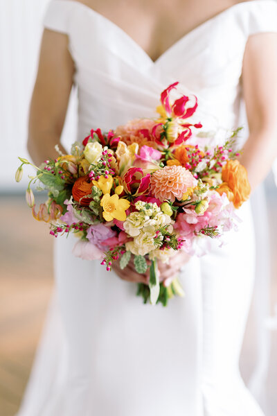 A close up of a bride holding a bouquet of flowers