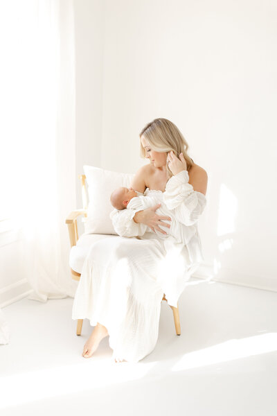 Mother holding baby in newborn photo shoot in Virginia Beach