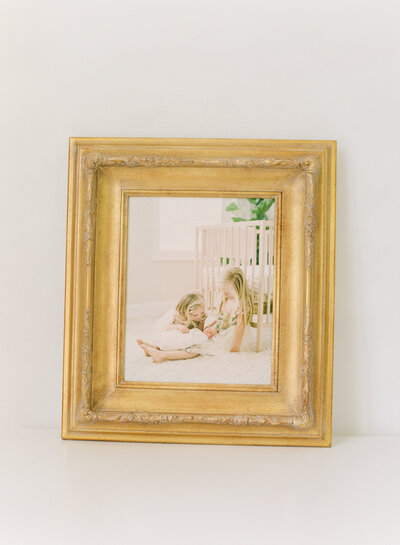 Gold framed canvas of three sisters from their Raleigh NC newborn photography session. Photographed by Raleigh family photographers A.J. Dunlap Photography.