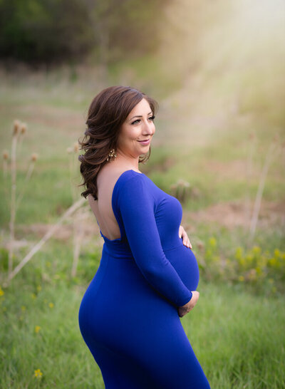 A beautiful pregnany mom in a royal blue gown.