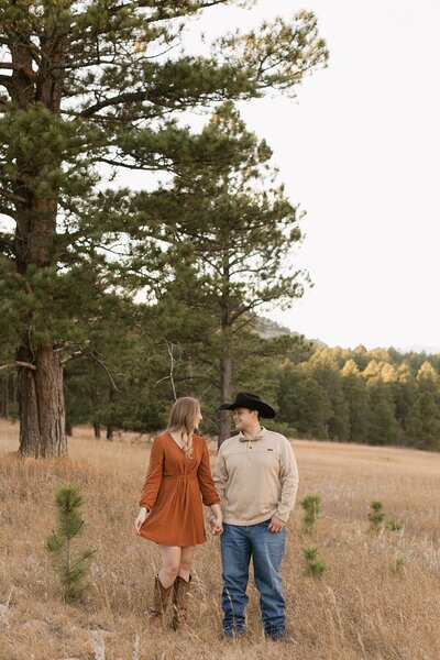 A couple smiling at each other during their engagement session on Iron Mountain Road.
