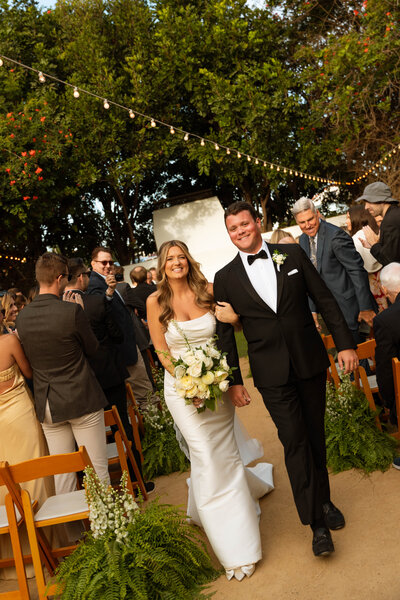 a bride and groom walking out of their wedding ceremony