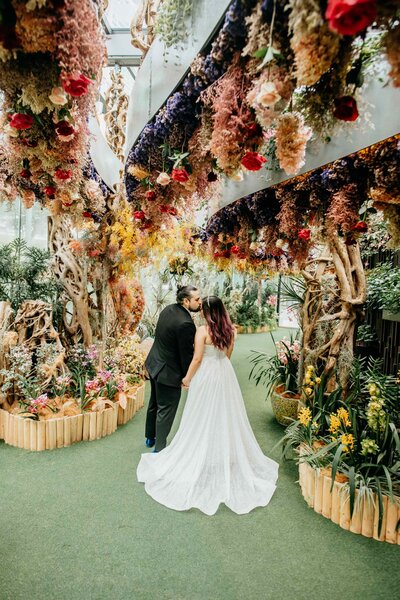 DC Calligrapher enjoying whimsical garden wedding with her husband kissing her forehead