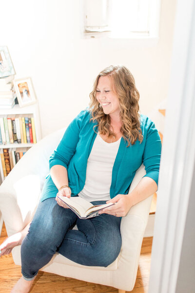 SEO consultant Julia Bocchese sitting on a white chair with a book