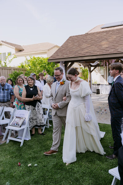 Regan's Father walking her down the aisle at her backyard wedding.