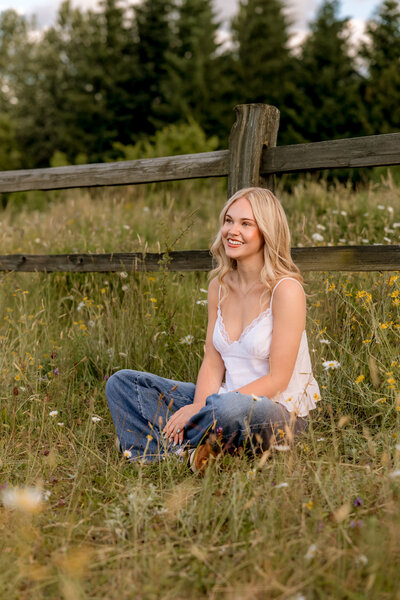 Girl sitting next to fence at powell butte park