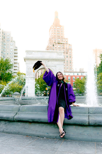 Graduate in cap and tam smiling during a portrait session at Washington Square Park in New York City.