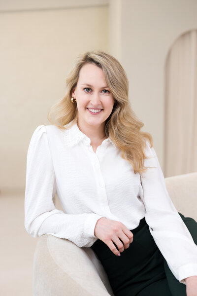 valerie greene headshot in white blouse and black pants sitting